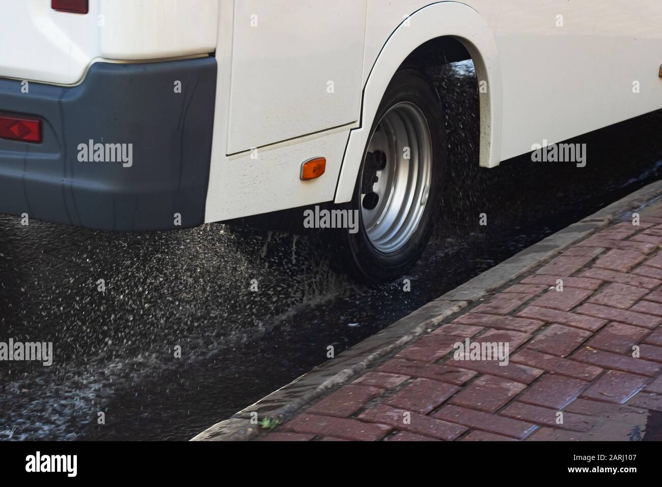 Water spray from under the wheels of a white car close up Stock Photo ...