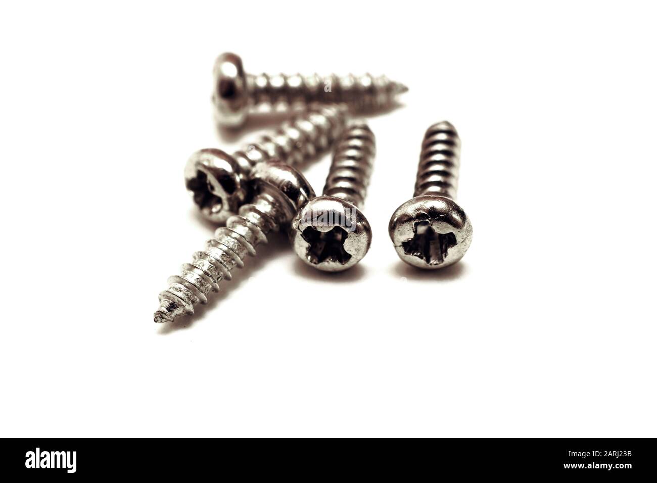 A pile of small metal bolts isolated on white background Stock Photo