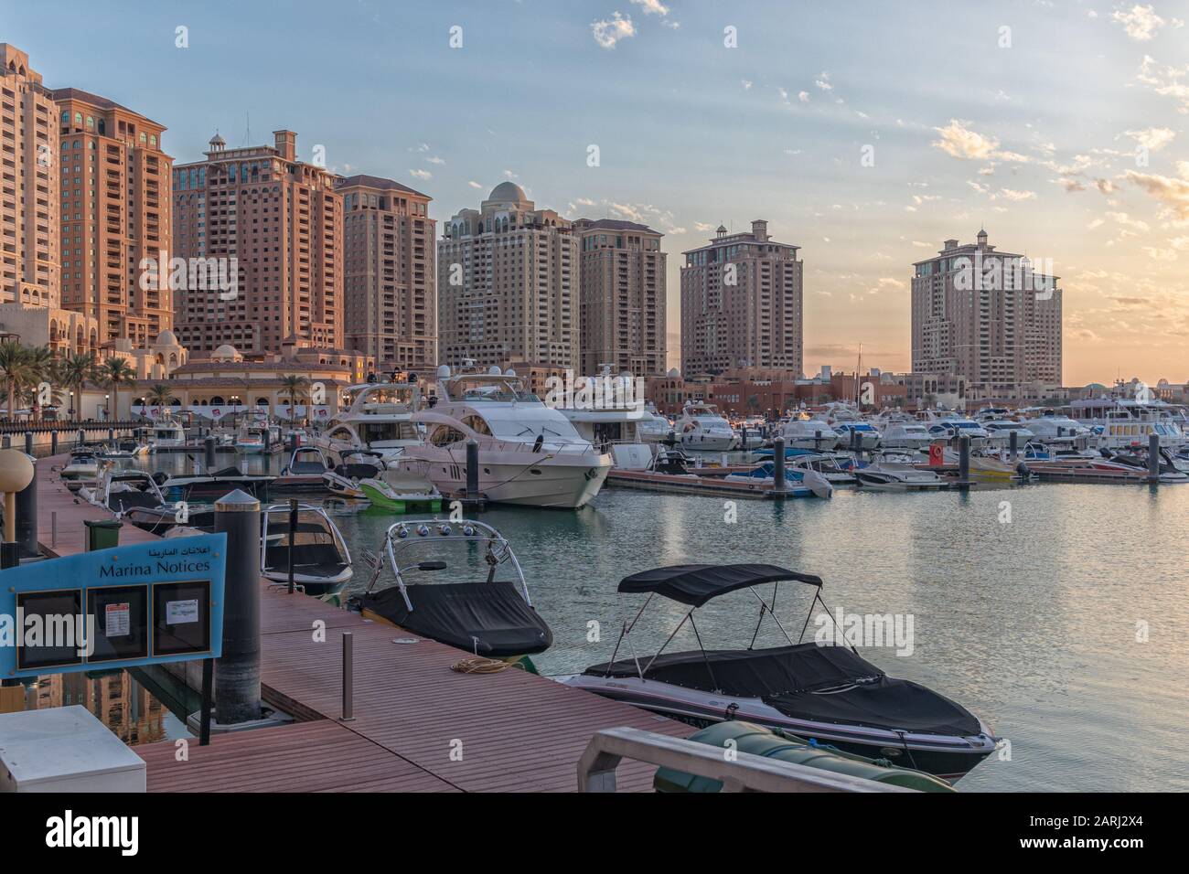 Doha,Qatar-January 25,2020:  The pearl Marina daylight view with Yachts in foreground, buildings and clouds in the sky in background Stock Photo