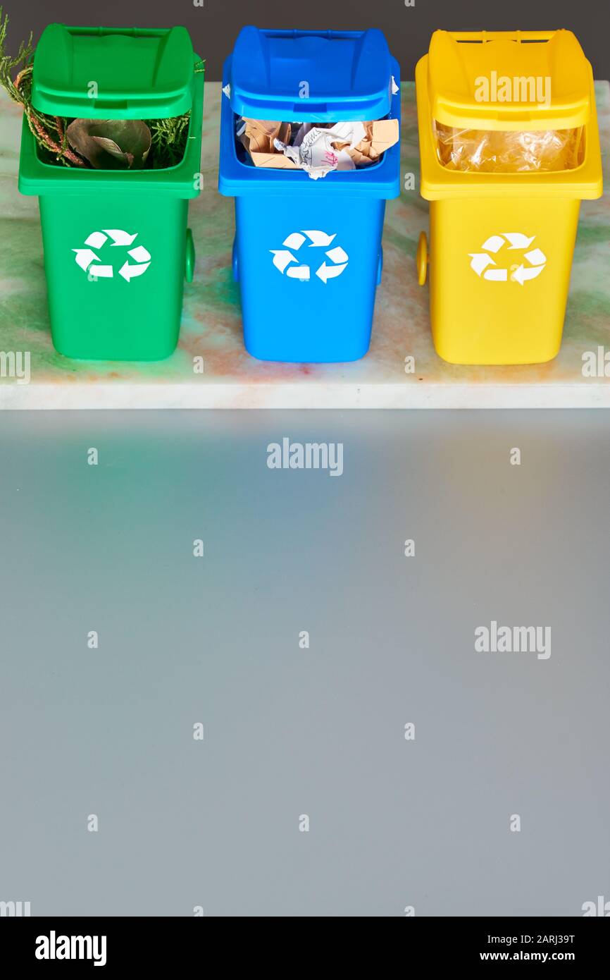 Three color coded recycle bins, isometric picture on grey background