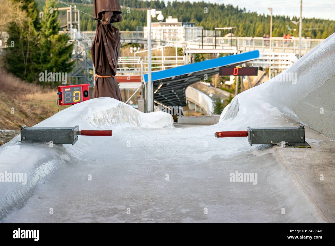 Bobsleigh ice channel in Winterberg. The digital clock measures the speed. Curvy trail in the ice. Stock Photo