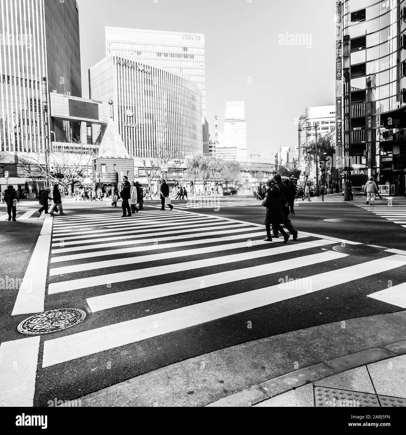 Tokyo, Japan - January 1, 2010: Pedestrians crossing the street at the heart of Ginza District in Tokyo. Ginza crossing in the afternoon. Stock Photo