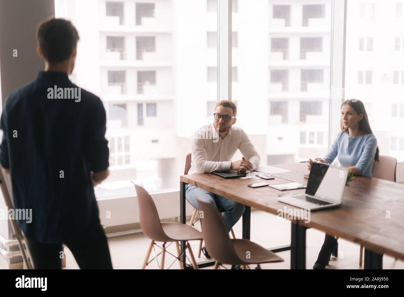 Businessman doing presentation, using whiteboard, explaining to colleagues Stock Photo