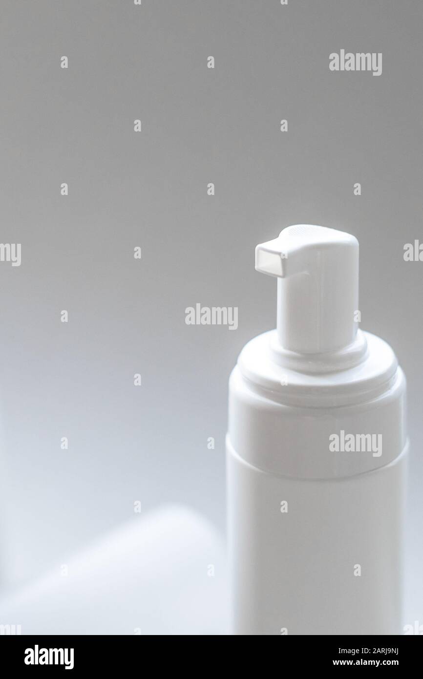 A closeup of foaming white plastic container for body and face care with a dispenser pump Stock Photo