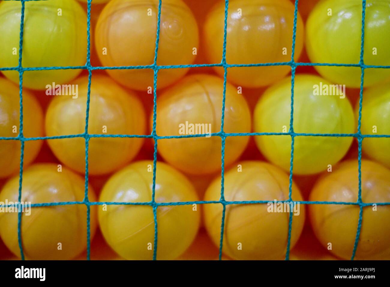 Yellow plastic balls behind the green net Stock Photo Alamy