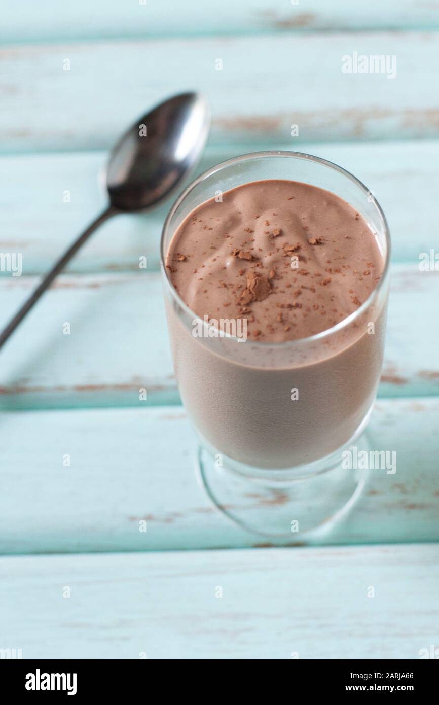 https://c8.alamy.com/comp/2ARJA66/chocolate-vegan-smoothie-inside-glass-on-blue-background-with-a-spoon-2ARJA66.jpg