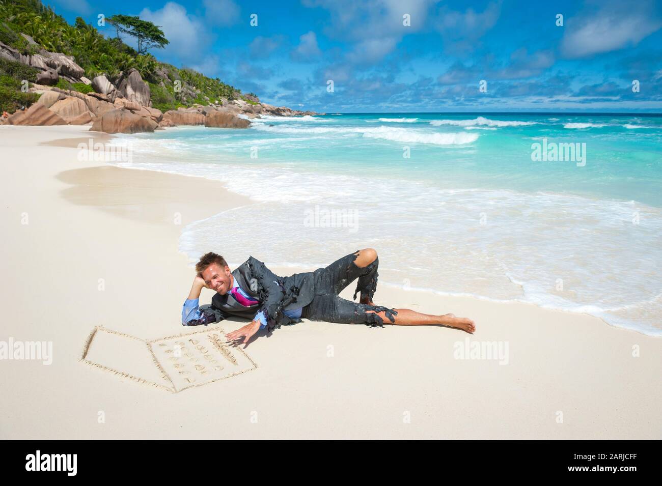 Castaway businessman typing on a tropical beach with a laptop computer hand drawn in smooth sand Stock Photo
