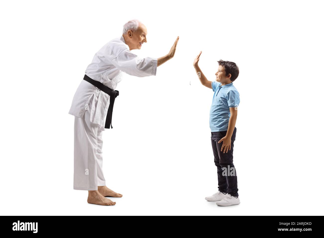 Full length profile shot of a boy and an elderly karate master gesturing high-five isolated on white background Stock Photo