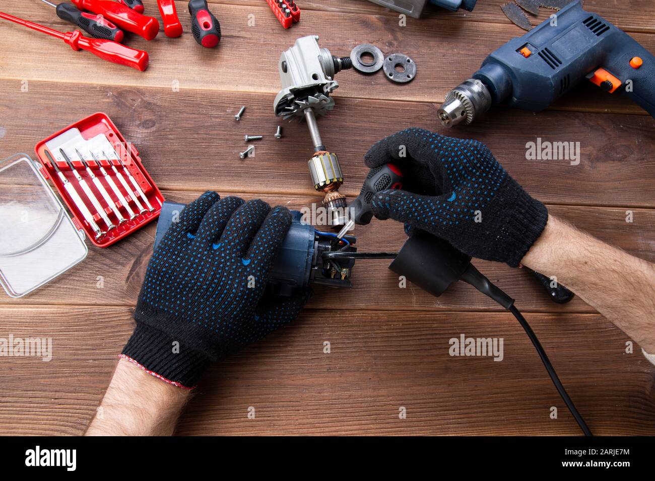 the master repairs a broken electrical device: drill, cutter on a 