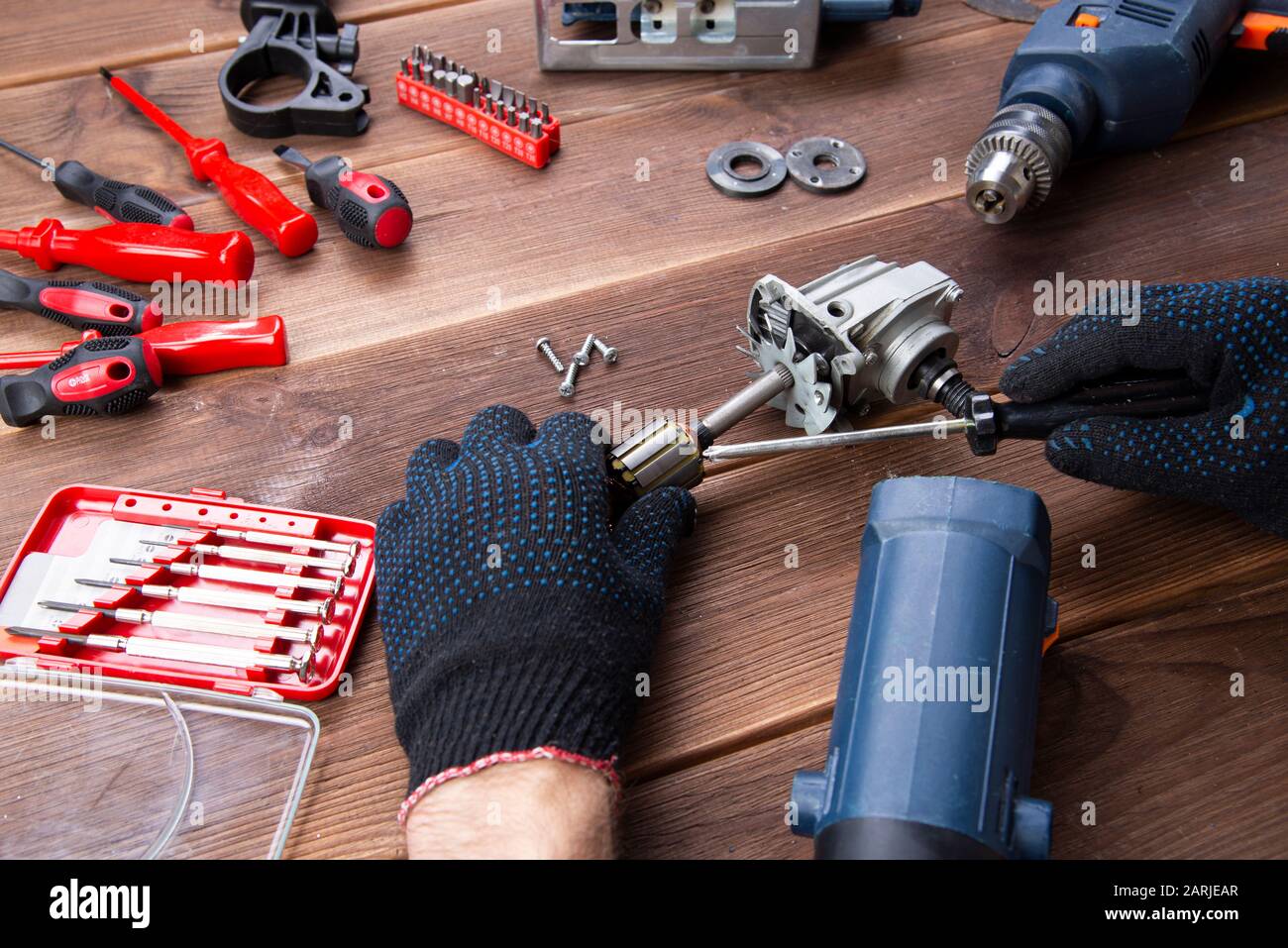 the master repairs a broken electrical device: drill, cutter on a wooden  table. Electric Tool Repair Shop Stock Photo - Alamy