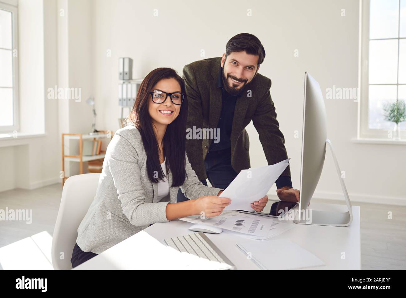 Business people smiling while standing in office. Stock Photo