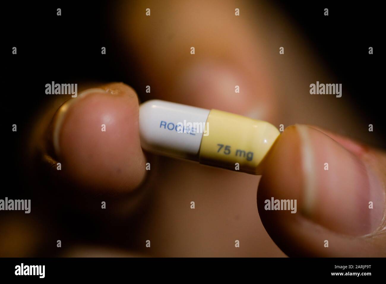 Bucharest, Romania - January 26, 2020: Close up image with the the fingers of a woman holding a Tamiflu capsule (oseltamivir), an antiviral medication Stock Photo