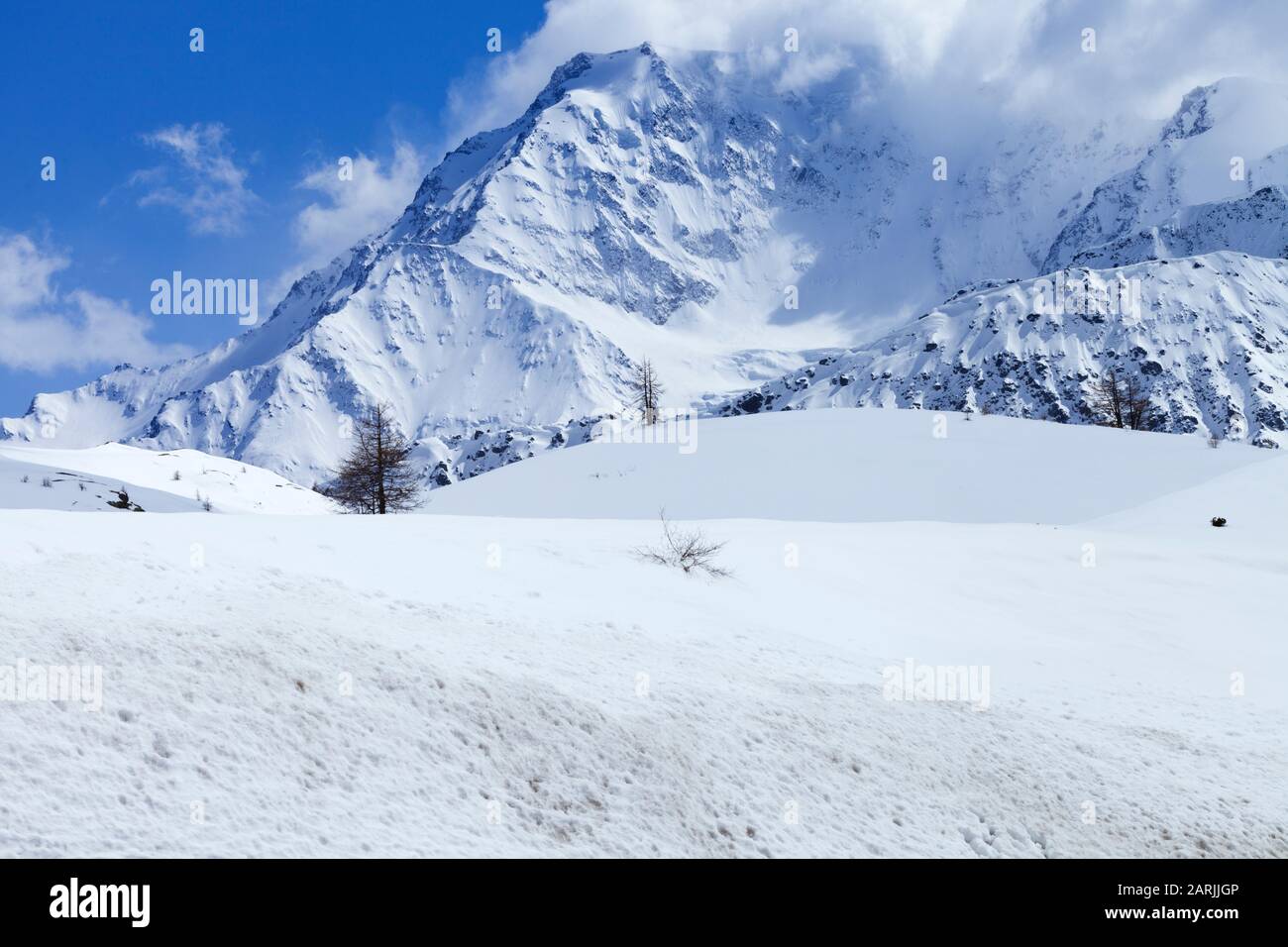 Snowy mountain covered with clouds, winter landscape in Swiss Alps . Stock Photo