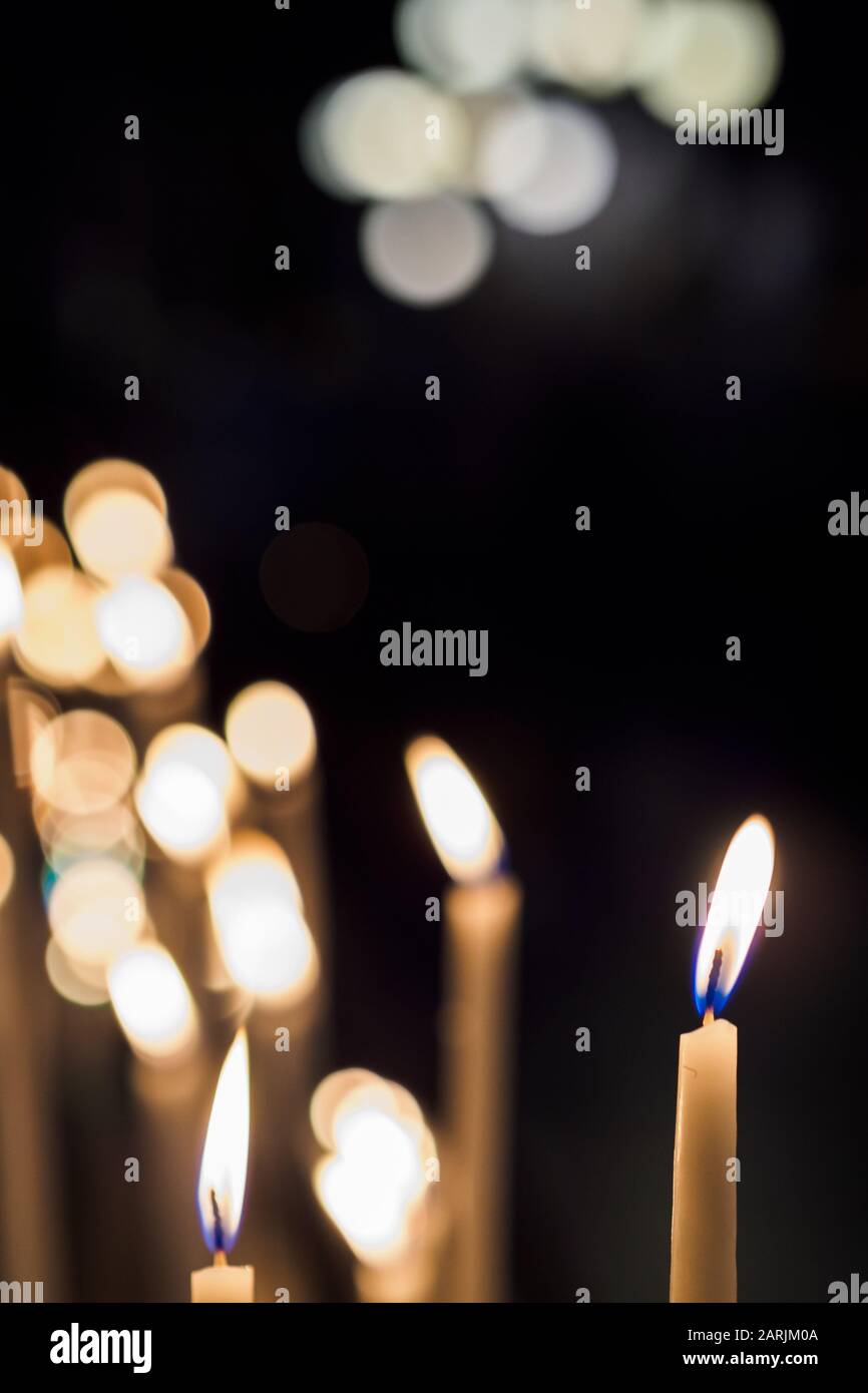 Burning candles in a church symbolizing wishes and prayers Stock Photo