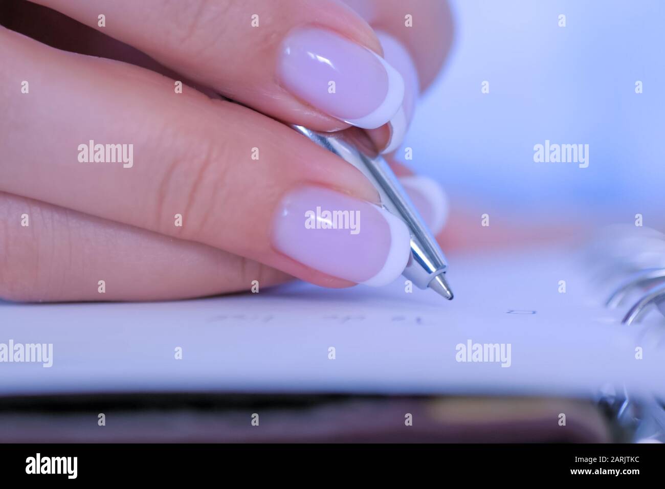 Woman hand holding pen and writing to do list in vintage notebook ...