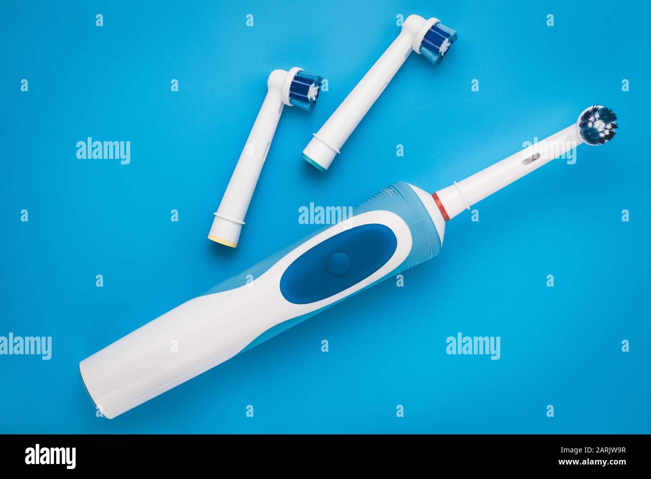 Electric toothbrush with nozzles, heads. Blue background. Oral hygiene concept Stock Photo