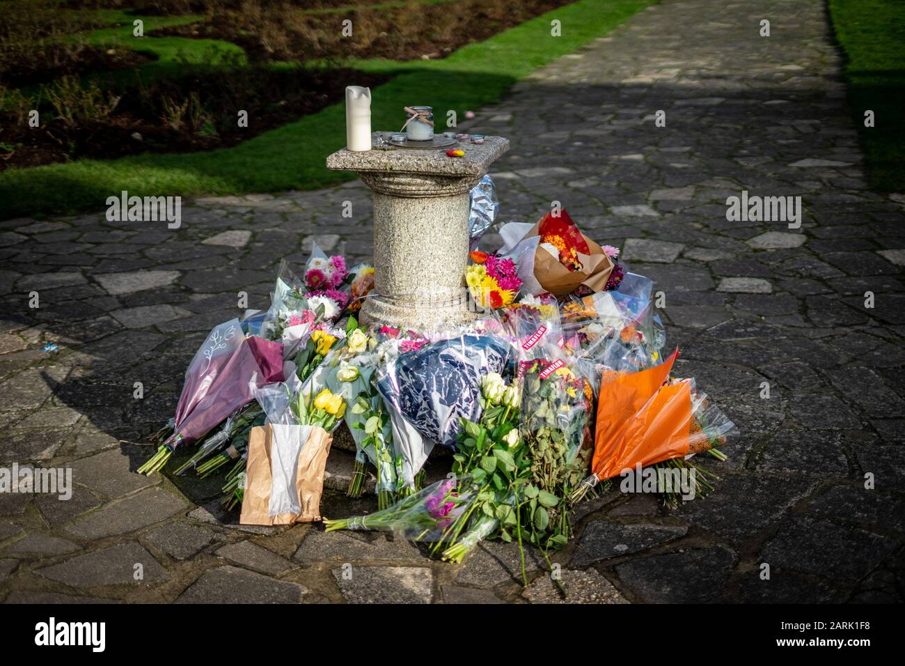 floral tributes around a monument left after the death of a family member Stock Photo