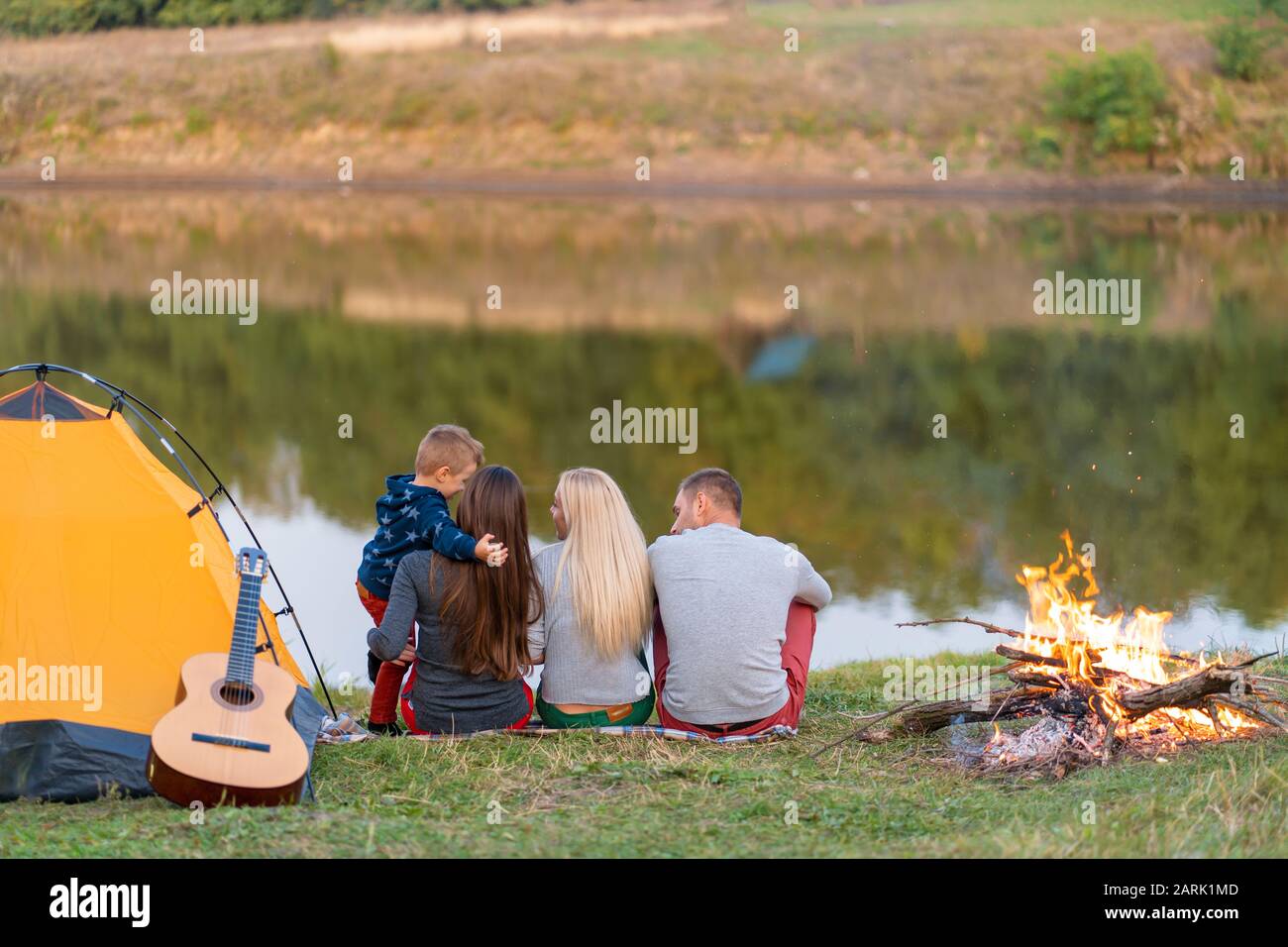 A group of friends is enjoying view, camping with bonfire on ...