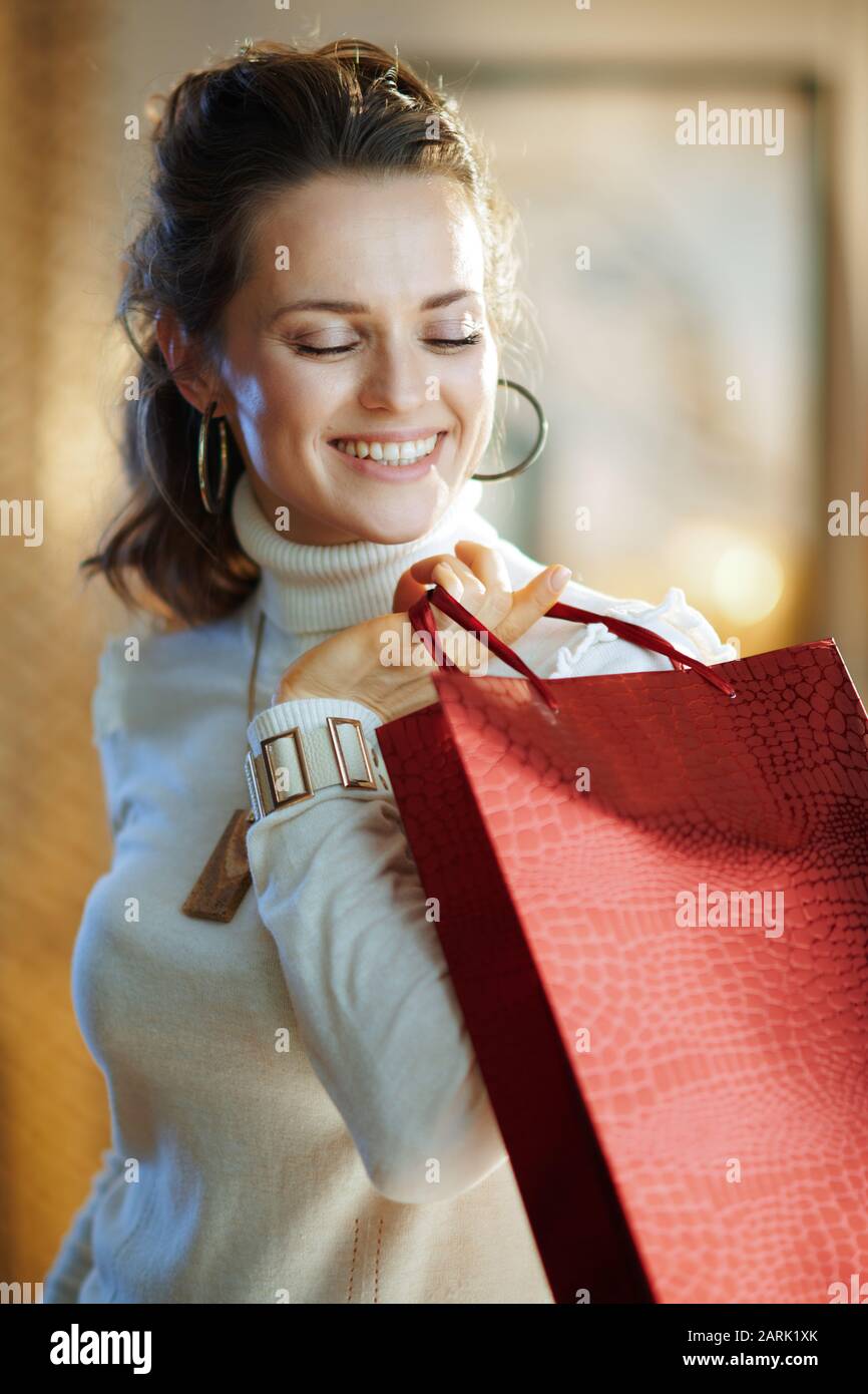 Portrait of happy elegant 40 years old woman in white sweater and skirt