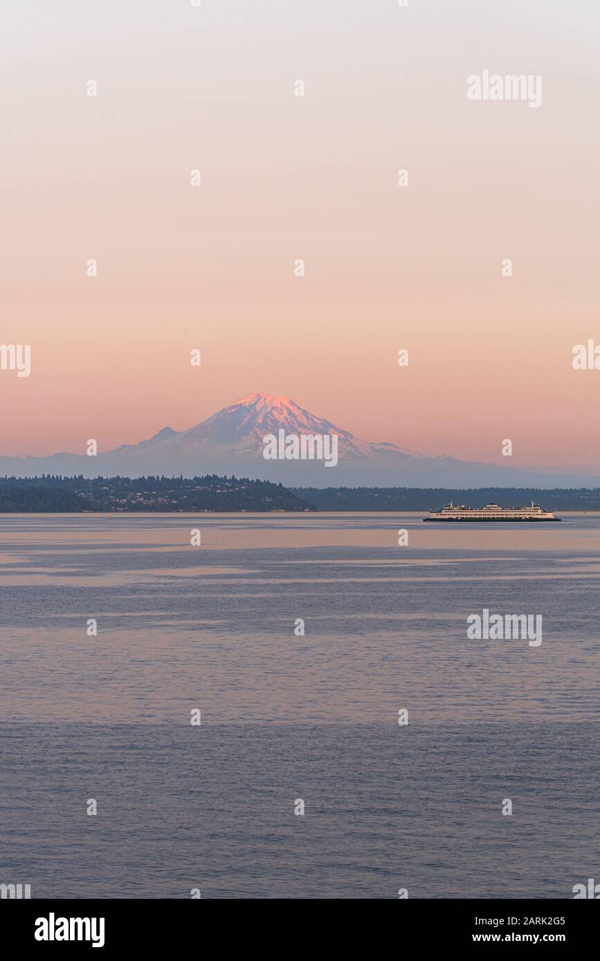 Washington State Ferry crossing Puget Sound at twilight with Mt Rainier beyond, from Seattle, Washington Stock Photo