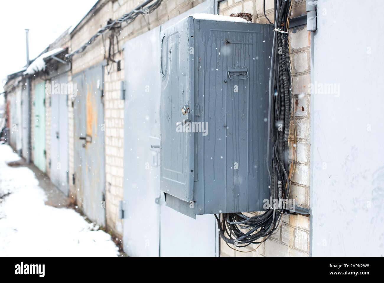 Old electrical communications box hanging on a wall in a garage cooperative. Stock Photo