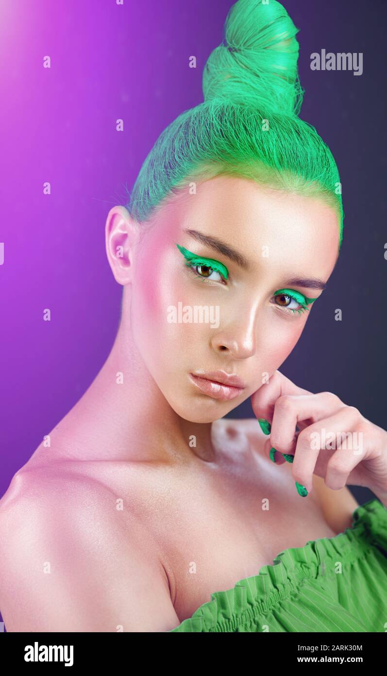 High fashion model. Amazing woman with green hairstyle and arrows on her eyes Stock Photo