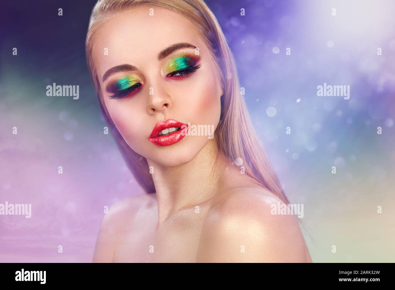 Cute blonde fashion model girl in trendy make-up. Eye models with colorful glitter on the eyelids Stock Photo