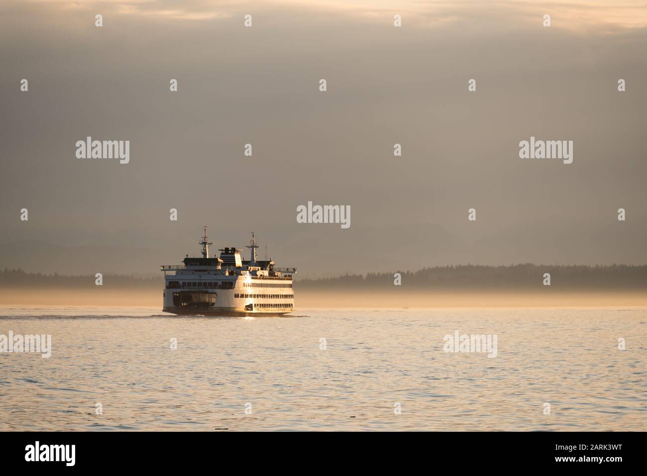 Washington State Ferry crossing Puget Sound at twilight with Olympic Mountains beyond, from Seattle, Washington Stock Photo