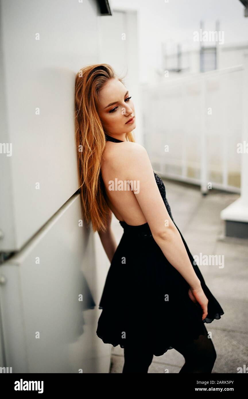 woman near the wall in a black dress Stock Photo