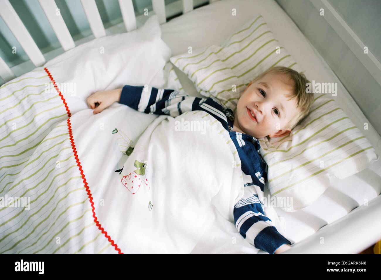 Little toddler boy in his crib not wanting to nap. Stock Photo