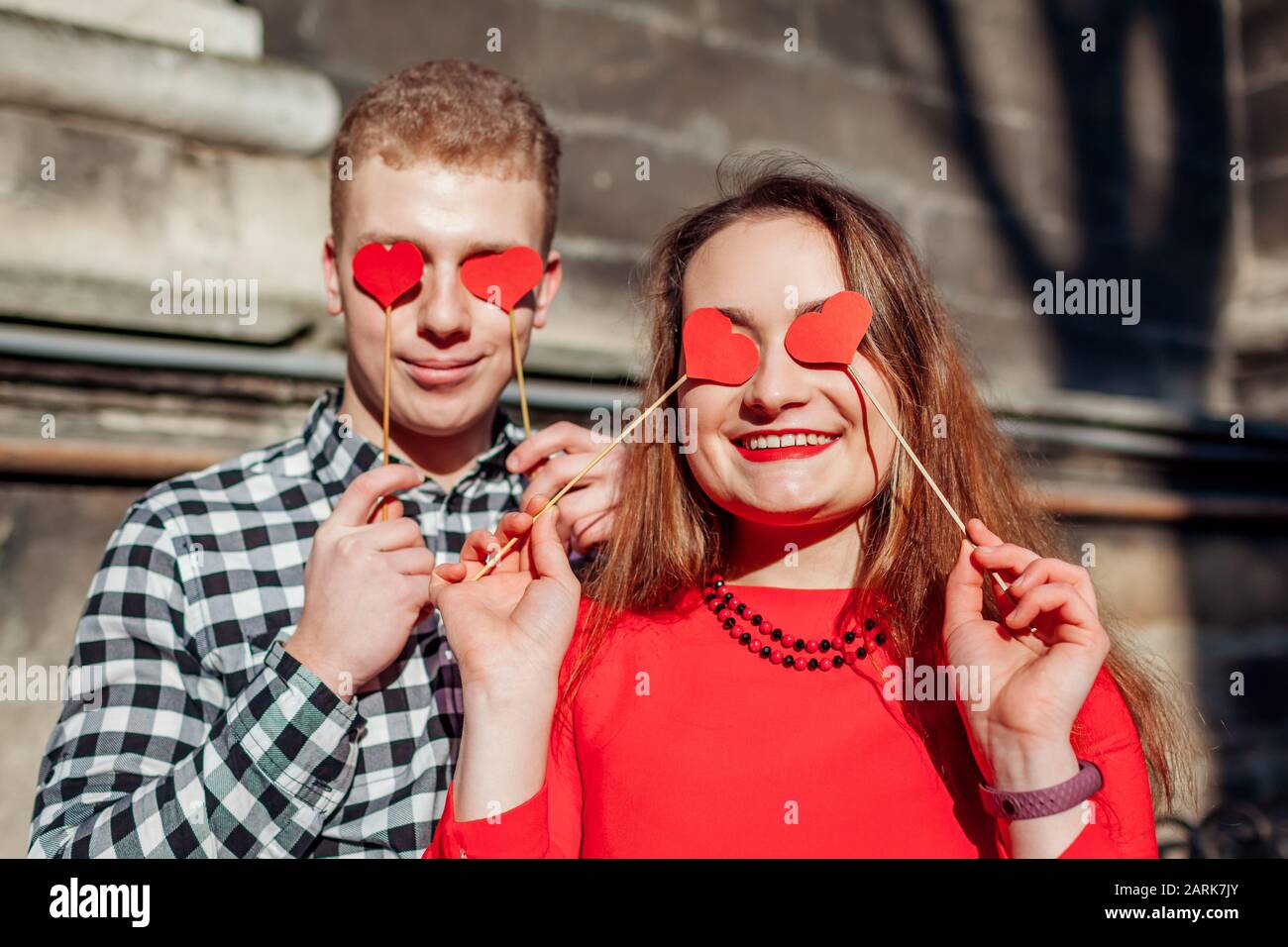 Valentines day photo booth props. Man and woman hiding eyes behind red