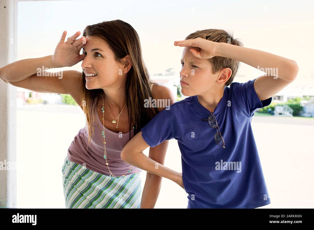 Midadult woman and her young son having fun mimicking each other by