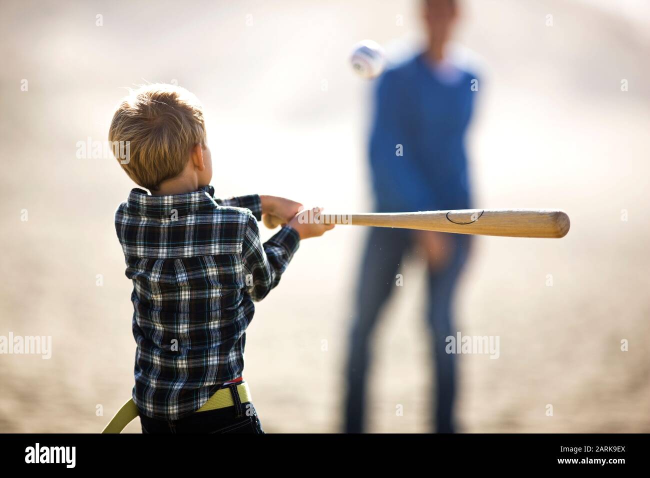 Young boy swinging a baseball bat at the beach Stock Photo Alamy