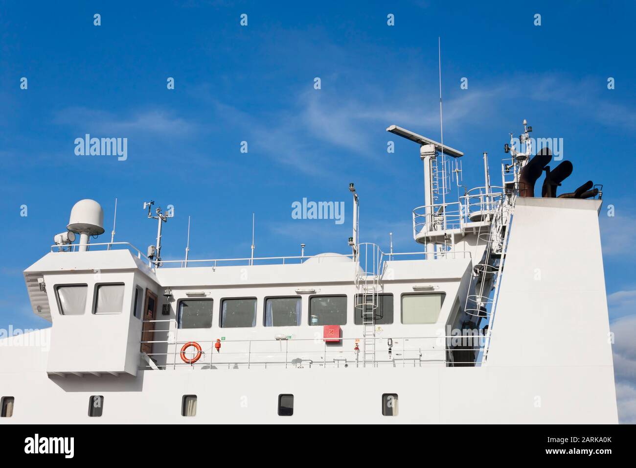 Watchtower, antennas, radar, anemometer and other communication and navigation equipment on the command bridge of a ship. Stock Photo