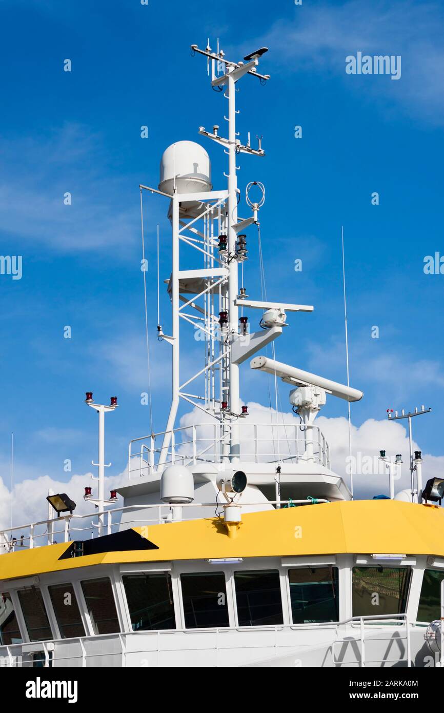 Command bridge, antennas, radar, anemometer and other communication and navigation equipment on the command bridge of a ship. Stock Photo