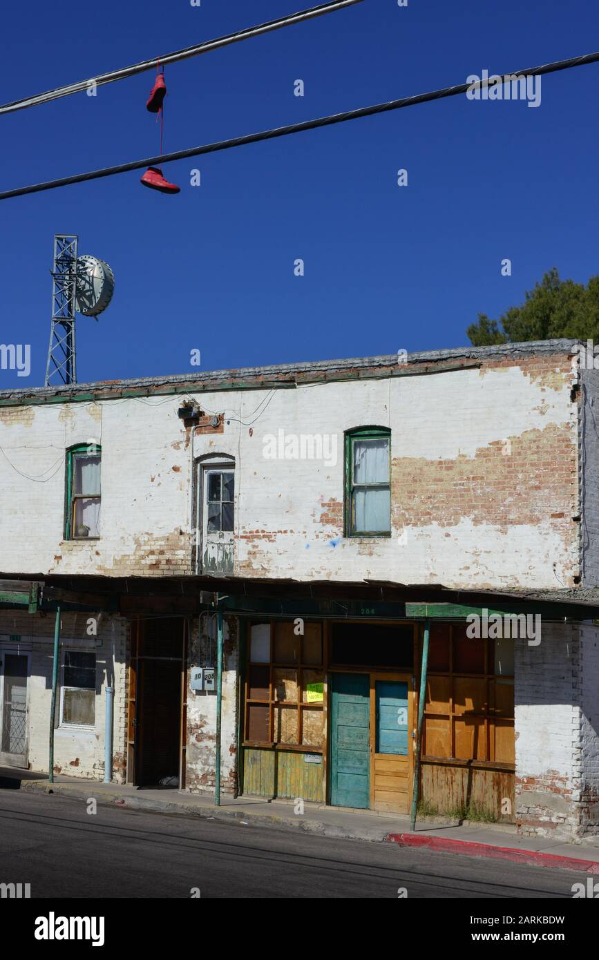 Red shoes hang from overhead wire near a funky run down old building with sign for apartment rentals, in the Mexican border town of Nogales, AZ, USA Stock Photo