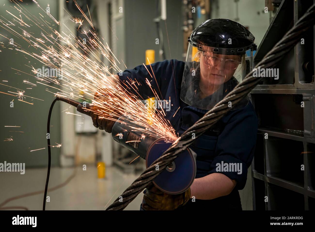NORFOLK (Dec. 18, 2019) Airman Bella Villareal, from San Antonio, assigned to USS Gerald R. Ford's (CVN 78) air department, grinds down a weld on an arresting gear cable during a cable re-reave evolution. Ford is currently in port after completing a successful independent steaming exercise. (U.S. Navy photo by Mass Communication Specialist 3rd Class Joshua Murray) Stock Photo
