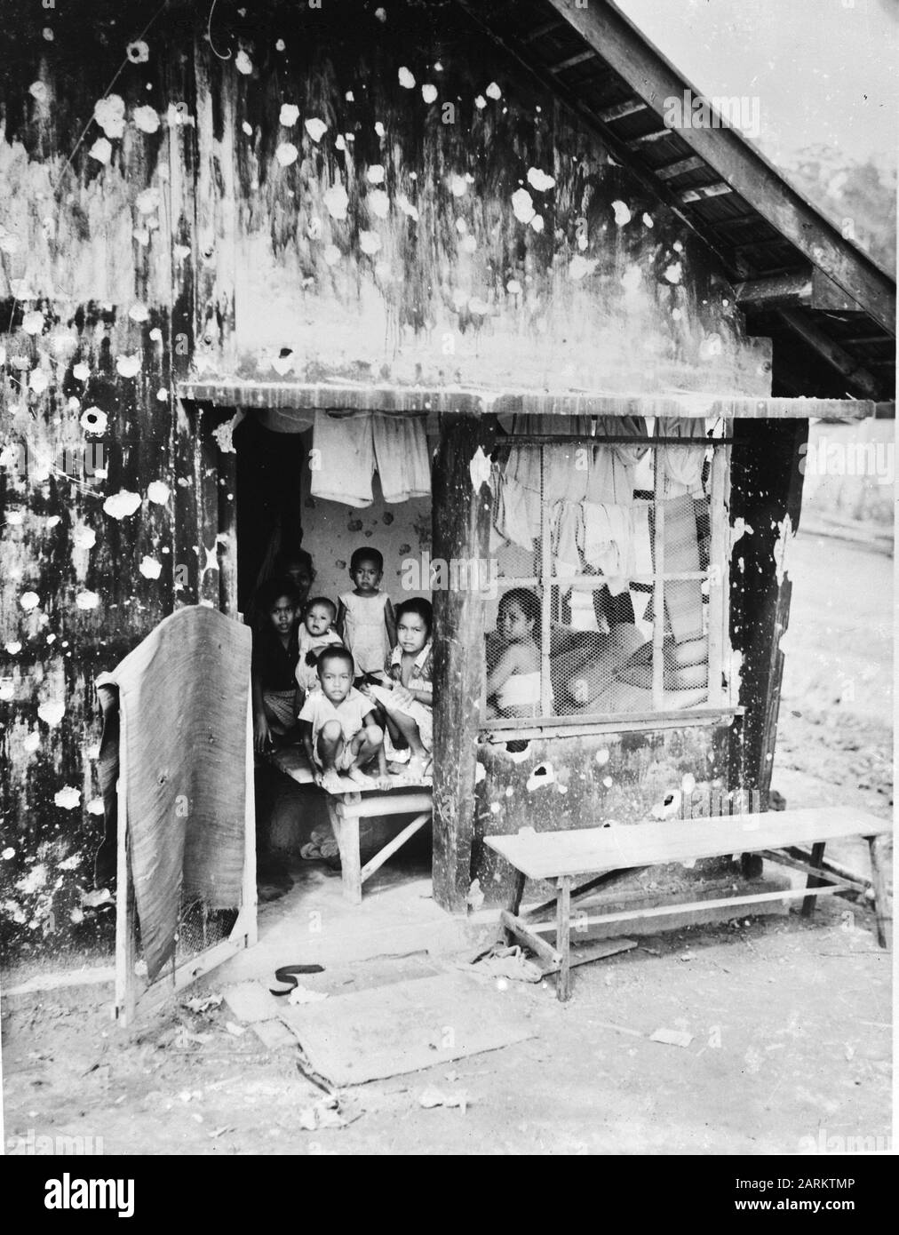 Tarakan. (Borneo, Dutch East Indies). [A family in a bullet-ridden barak/hut] Date: 1945 Location: Indonesia, Dutch East Indies Keywords: Second World War, destruction Stock Photo