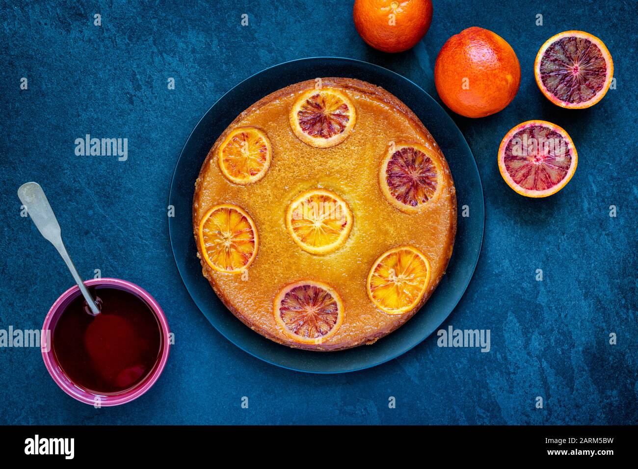 Homemade upside down blood orange cake with blood orange syrup on a slate background Stock Photo