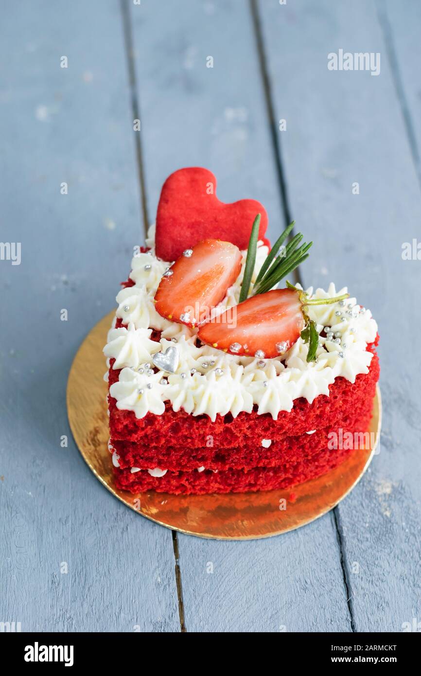 Red Heart Shaped Cake Decorated With White Whipped Cream Slices Of