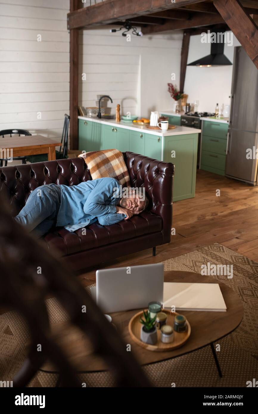 Man sleeping on the leather sofa at home Stock Photo Alamy