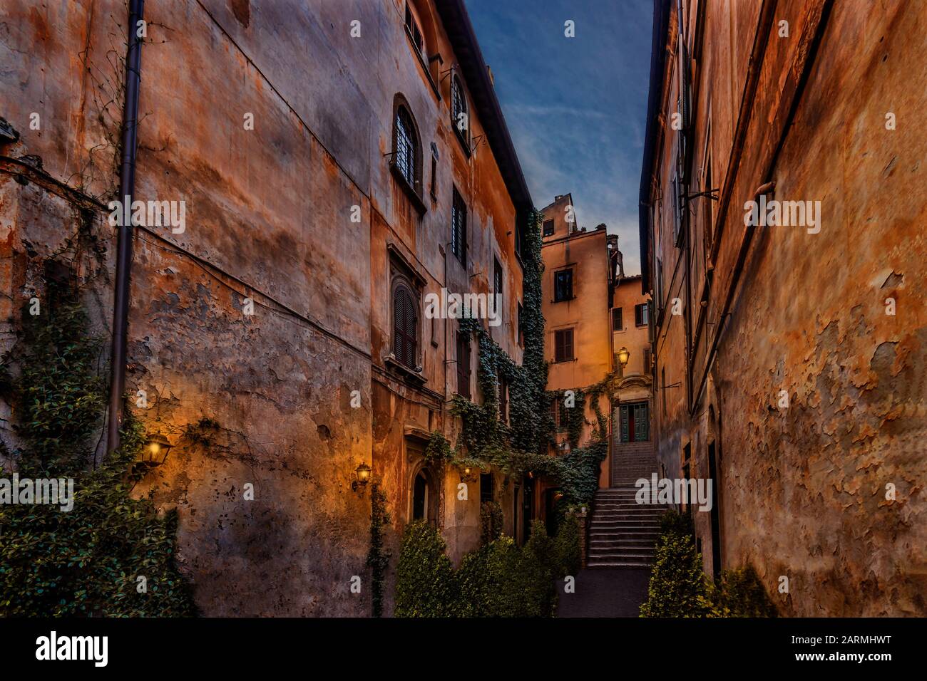Historic alley in Rome Italy with old traditional houses illuminated at night Stock Photo