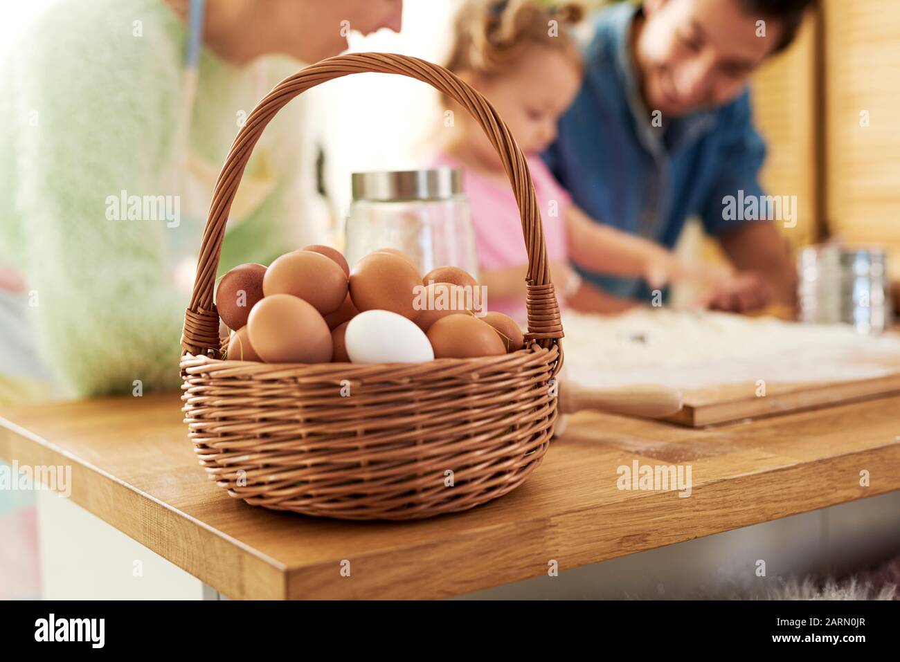 A full basket of eggs and family in the background Stock Photo