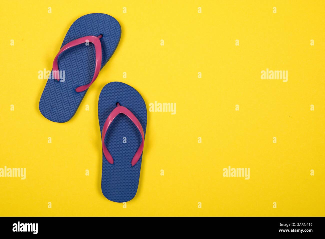 Pink and blue flip flops on a yellow background with copy space Stock ...
