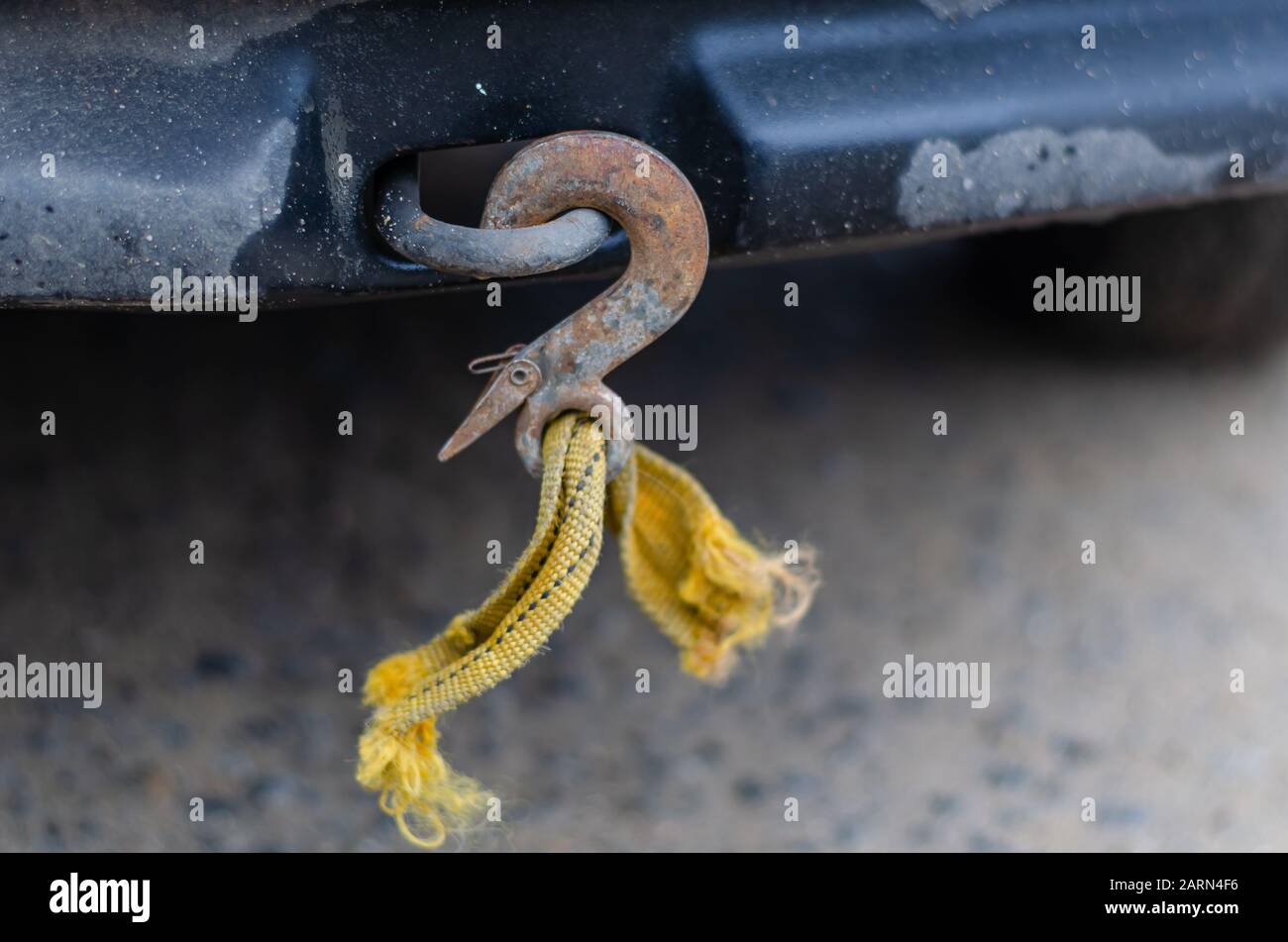 A tow rope with a hook broken during towing. Rusty hook with the rest of the orange cable
