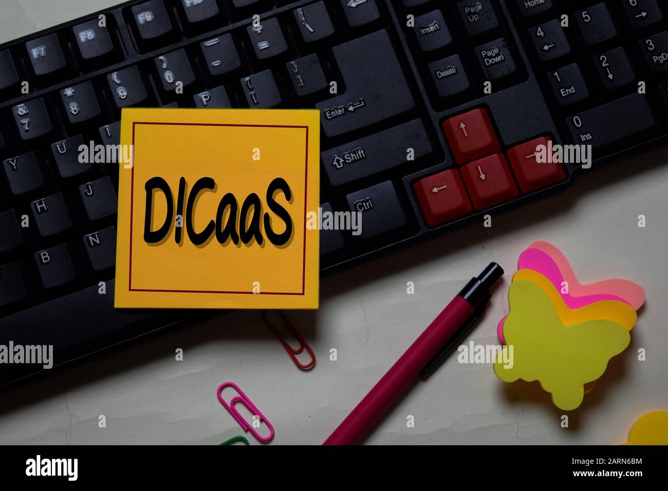 DICaaS - Data Intensive Computing as a Service write on a sticky note isolated on office desk. Stock Photo
