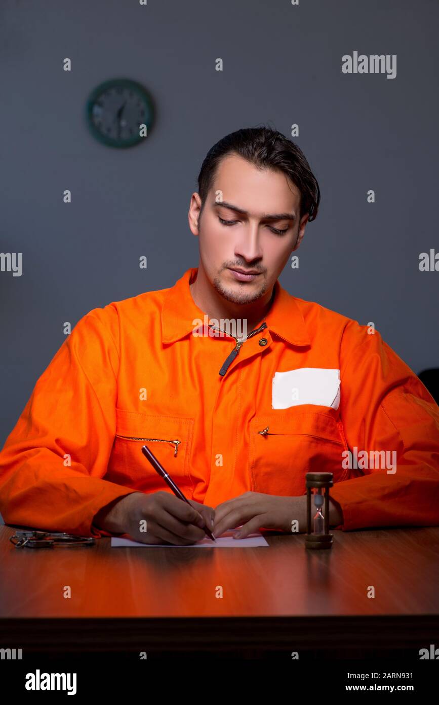 The young convict man sitting in dark room Stock Photo