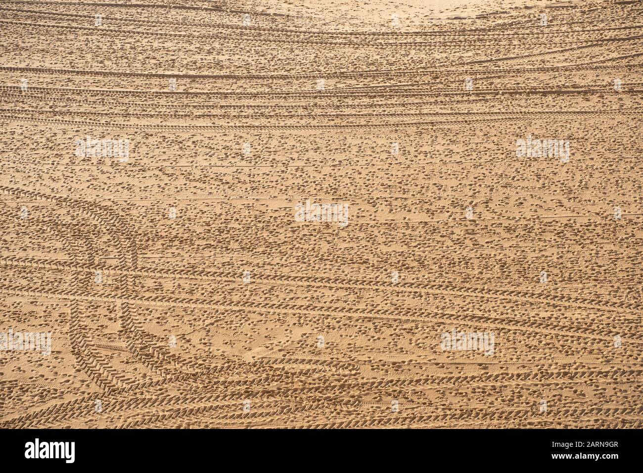 Tire tracks and footprints all over the sandy beach. Taken in Albuferia, Portugal Stock Photo