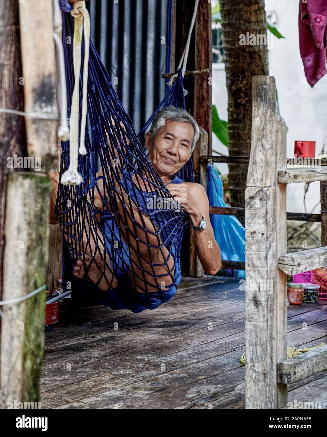 Morning’s work done. Time to siesta in the home hammock. Vietnamese people are professional nappers. Stock Photo
