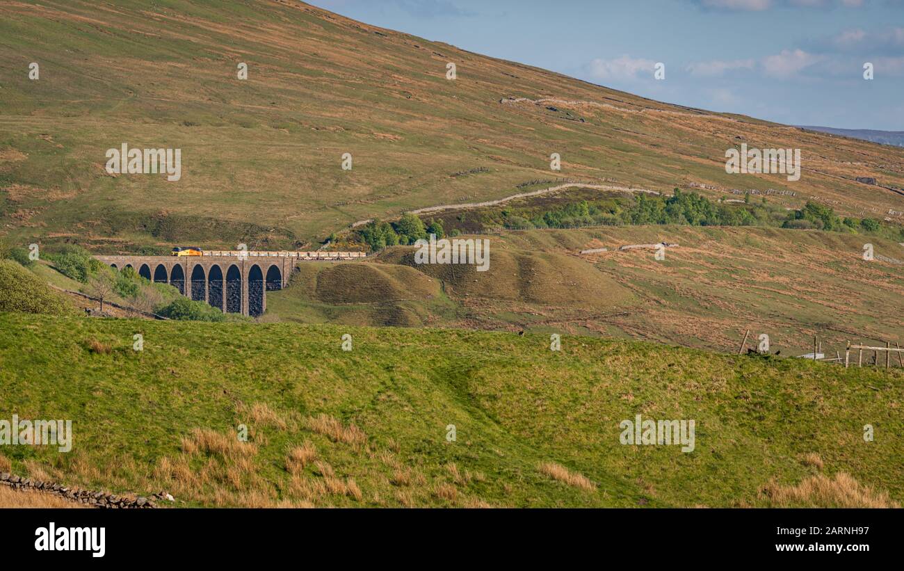 Near Cowgill, Cumbria, England, UK - May 16, 2019: A train passing the Arten Gill Viaduct on the Settle-Carlisle Railway line Stock Photo